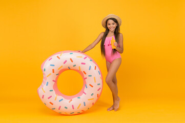 Enjoying suntan and vacation. cheerful small girl in swimsuit and straw hat. pool beach fun. child with tanning product. small beauty. happy kid and rubber ring. summer vacation activity. tanning oil