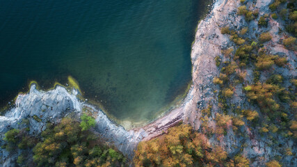 Top-down view rocky beach and clear blue water background.Beach located on the baltic sea coastline, Saaristomeri.