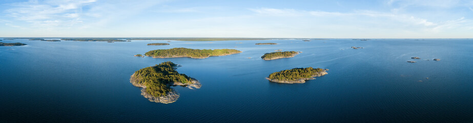 Aerial view of beautiful islands with green trees and rocks on the baltic sea at sunset in summer. Colorful landscape with island. Top view. Nature, Finland.

