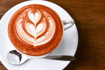 Coffee cup with latte art foam on wood table in coffee shop with copy space.Coffee is one of the most popular beverages.