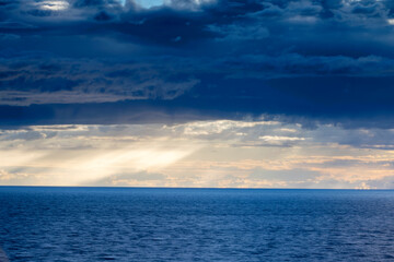 Fototapeta na wymiar Dark grey storm clouds over ocean