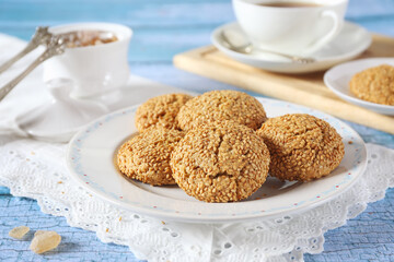 Sesame cookies and cup of tea, sweet breakfast on blue background