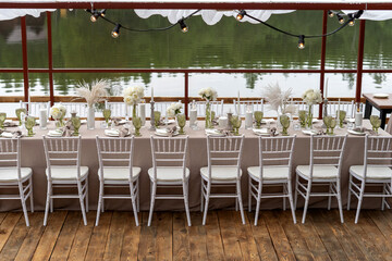 Decorated wedding table, white peonies and feathers. Chiavari chairs are at the table-3.