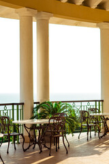 outdoor summer terrace, with cast iron.stylish furniture, in a cafe at sunset