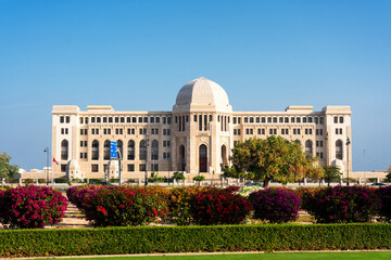 Muscat, Oman - 21 November, 2018: Scenic view of the Supreme Court building on blue sky background. Muscat is a popular tourist destination of the Middle East - obrazy, fototapety, plakaty
