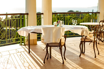 outdoor summer terrace, with cast iron.stylish furniture, in a cafe at sunset