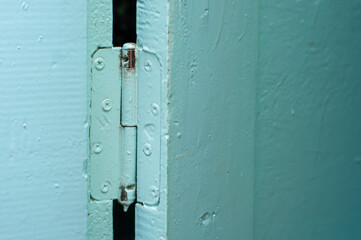 Door hinge of an old blue wooden door