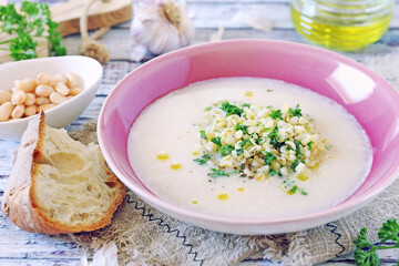 White bean vegetarian cream soup with fried pearl barley and parsley