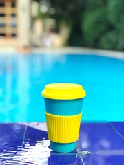 Fototapeta na wymiar reusable bamboo mug at the swimming pool