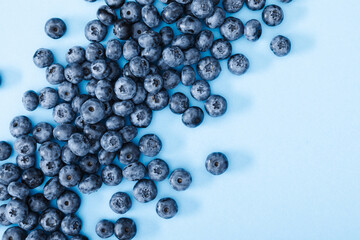 Fresh berries blueberry on blue background. Colorful fruit pattern of blueberries as background....