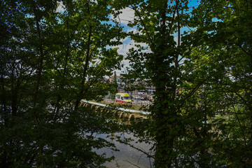 Yellow and Red Icecream Van in the Distance on a Bridge Through the Trees