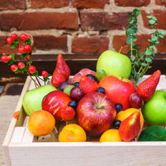 Large collection fresh fruits useful for health on the red brick wall background. Harvesting concept. Space for text.
