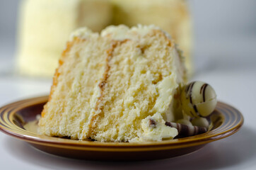 A piece of layered white cream cake with confectionery decorations