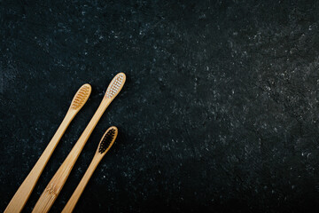 Three dental bamboo brushes on black background,