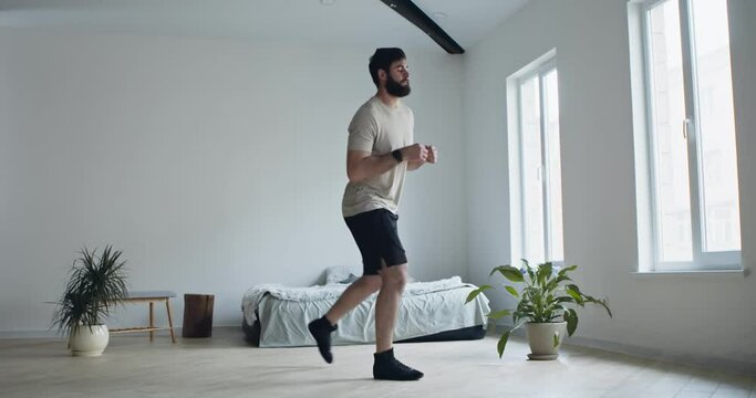 Bearded man doing lunges exercises for leg at home