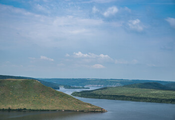 Beautiful landscape of a big river with mountains under a blue sky.