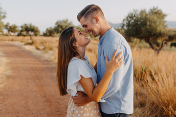 young couple man and woman rubbing their noses and laughing in a rural setting 