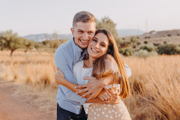 young couple happy girl and guy are hugging and looking at the camera lens