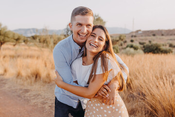 young couple happy girl and guy are hugging and looking at the camera lens