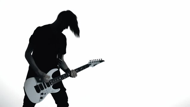 Silhouette of guitarist playing electric guitar