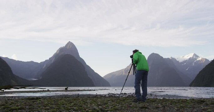 Travel landscape nature photographer tourist taking photo of Milford Sound and Mitre Peak in Fiordland National Park, New Zealand