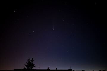 Comet C/2020 F3 Neowise right above silhouettes of city house roofs