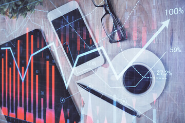 Double exposure of forex chart hologram over desktop with phone. Top view. Mobile trade platform...