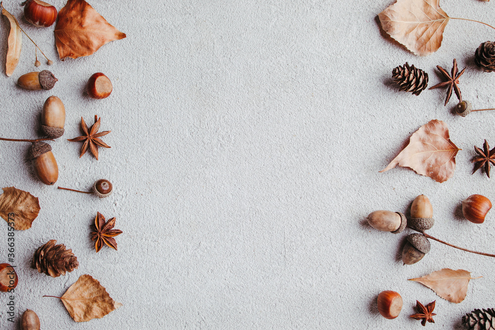 Sticker Hello autumn. Fall background made of dried yellow leaves and acorns with copy space. Seasonal composition, fall, thanksgiving day concept. Flat lay, top view