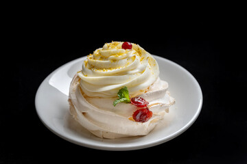 Pavlova meringue cake with fresh berries on black background.