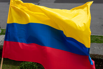 Colombian flag in wooden flagstick  waving with the wind at residential  neighborhood in colombia's independence day celebrations