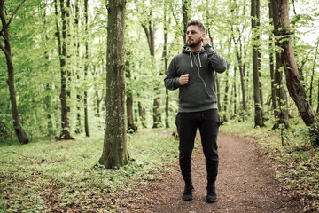 Adult sporty man in forest, park running in the morning