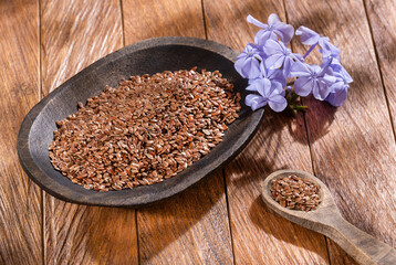 Organic flax seeds in the wooden bowl - Linum usitatissimum