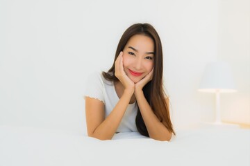 Portrait beautiful young asian woman relax happy smile on bed with white pillow blanket