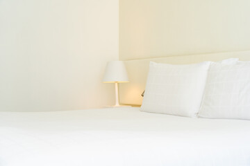 Fototapeta na wymiar White comfortable pillow and blanket with light lamp