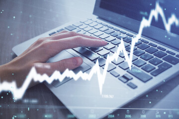 Double exposure of woman hands typing on computer and forex chart hologram drawing. Stock market analysis concept.