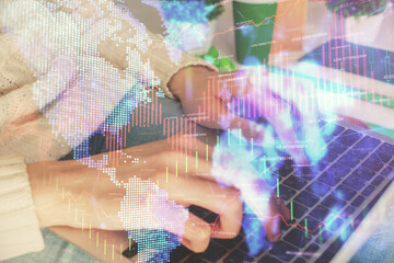 Double exposure of woman hands typing on computer and forex chart hologram drawing. Stock market invest concept.