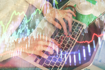 Double exposure of woman hands typing on computer and forex chart hologram drawing. Stock market invest concept.