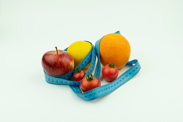 lemon, apple, orange, tomatoes wrapped in blue roulette. Fruit, Slimming, diet isolated on a white background.