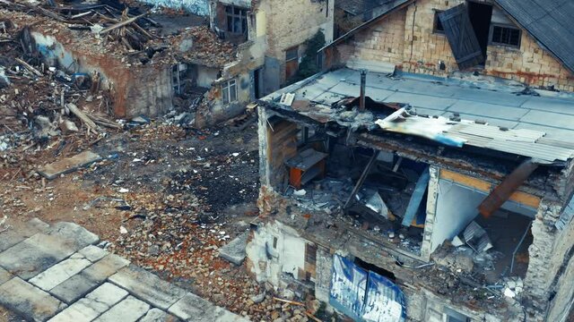 Abandoned ruins of a single-family home (detached house) on a deserted street. Aerial view