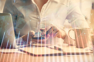 Double exposure of forex chart sketch hologram and woman holding and using a mobile device. Financial market concept.