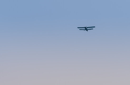 Military biplane flying in clear blue sky