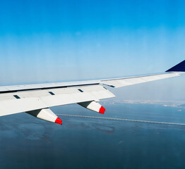 Aircraft wing flying over ocean