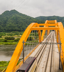 Top view of train crossing yellow bridge