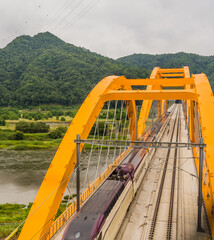 Top view of train crossing yellow bridge
