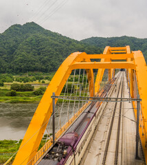 Top view of train crossing yellow bridge
