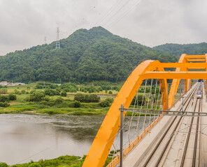 Top view of train crossing yellow bridge