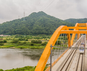 Top view of train crossing yellow bridge