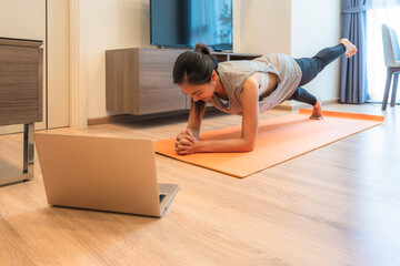 Fit Asian woman workout exercise at home during Covid 19 