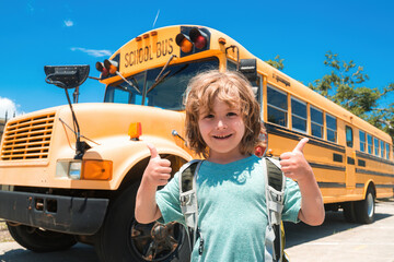 Happy school child. Child from elementary school with bag on school bus backgroung. Success sign...