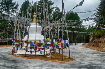 Chorten and  prayer flags  in the snow repeating mantra